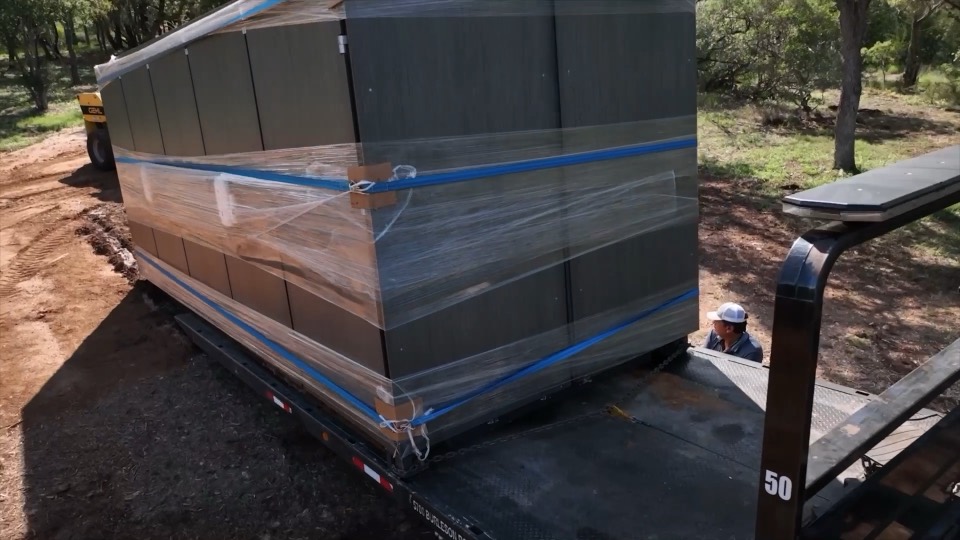 A REV vault arriving on a flatbed trailer